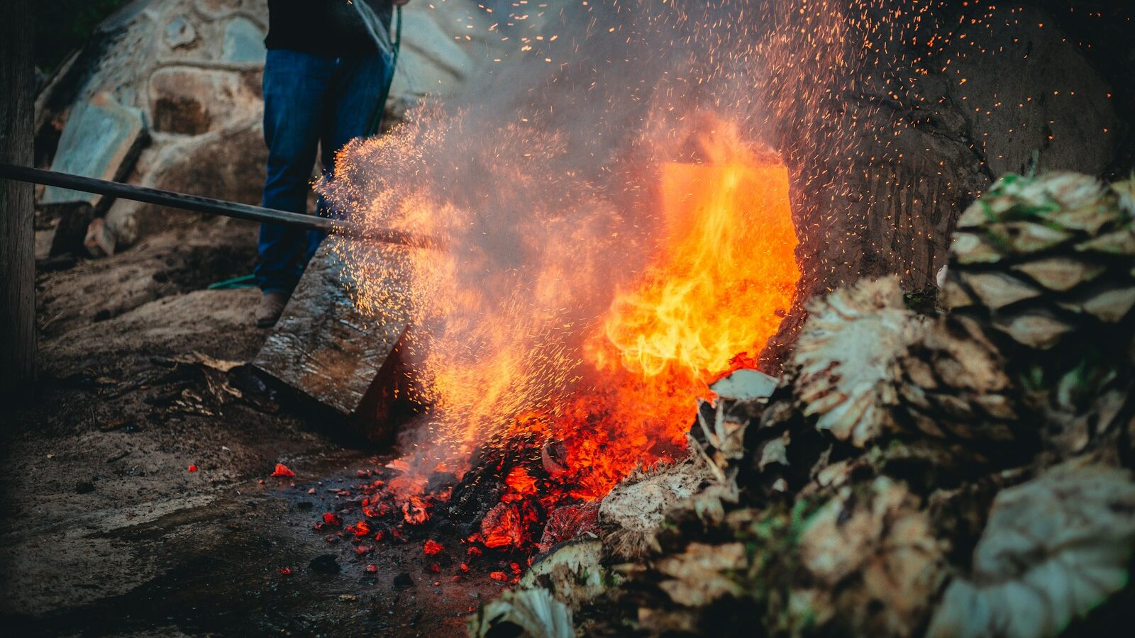 a man standing next to a pile of fire